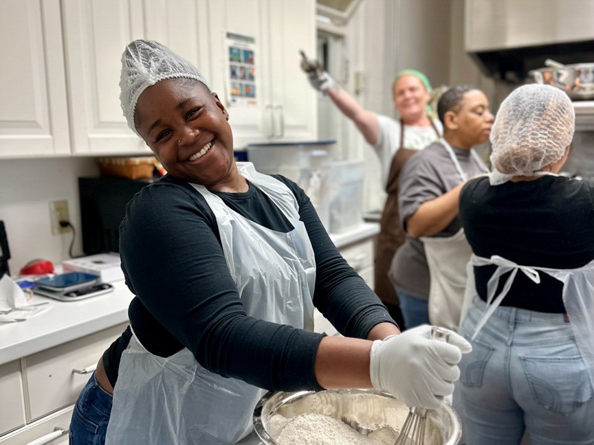 Team members learn and bond in the kitchen. Impact