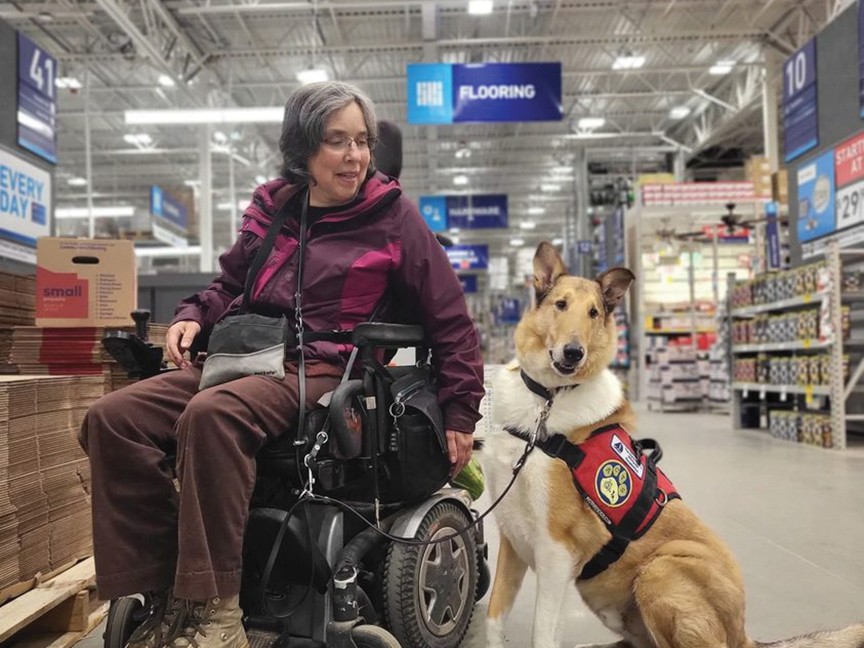 Joan and her ACTS service dog, Debit, smile during an outing to a local store. This devoted team recently celebrated their 4-year recertification, continuing their journey of independence and partnership together. Impact