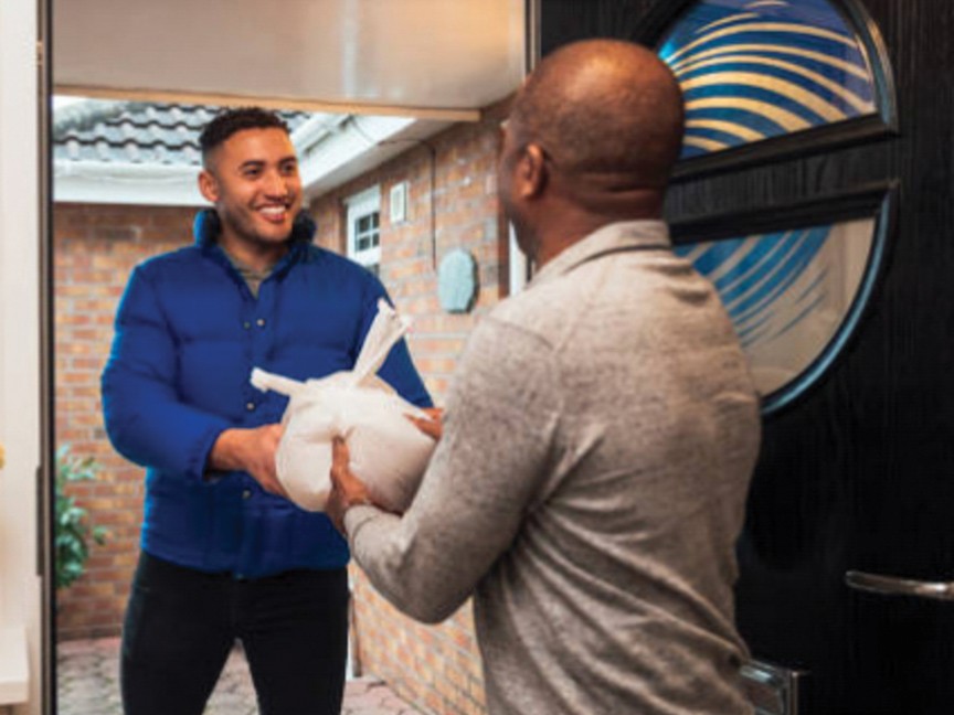 A Meals on Wheels volunteer driver delivering food to a homebound senior. Impact