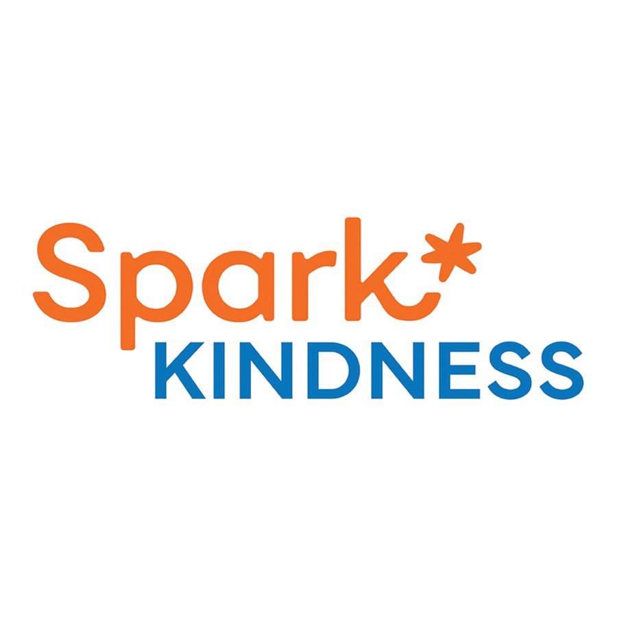 Group photo of Spark Kindness staff, volunteers, and MetroWest Subaru team holding a large donation check from Subaru's Share the Love Event, in front of the Spark Kindness tent.