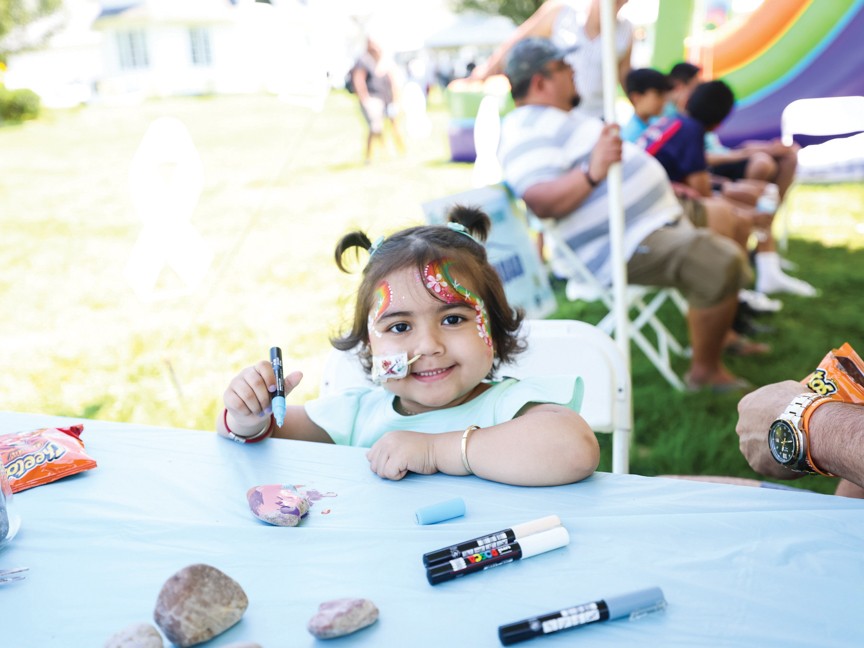 Leukemia warrior painting rocks at the 2nd annual Family Fun Day. Impact