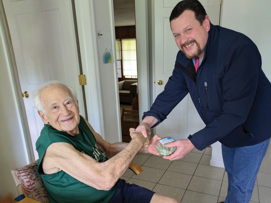 Staff delivering a meal with a special treat to a Meals on Wheels participant. Impact