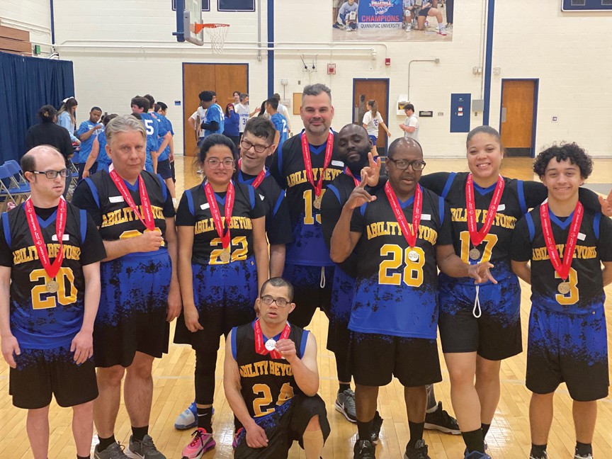 Smiling members of Ability Beyond Disability's Special Olympics Basketball team proudly wear their medals and celebrate their well-earned win at the 2024 games. Impact
