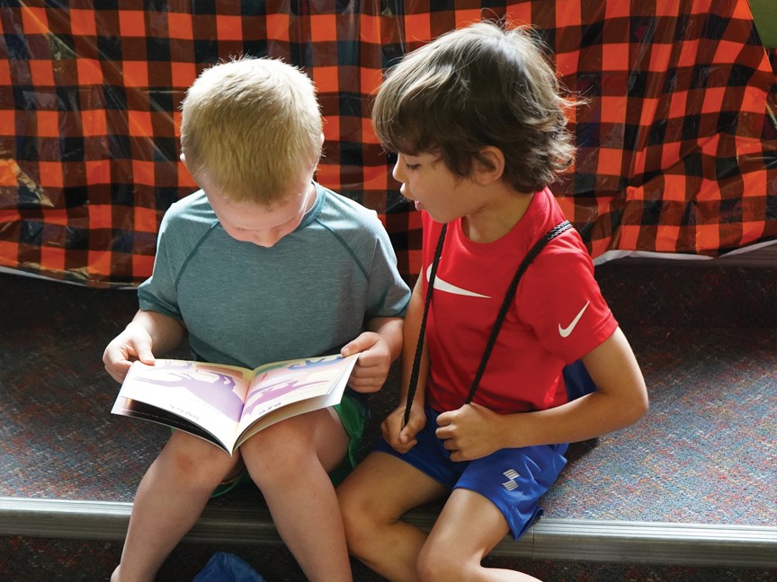 Two boys engaged with their new books that they will cherish forever. Impact
