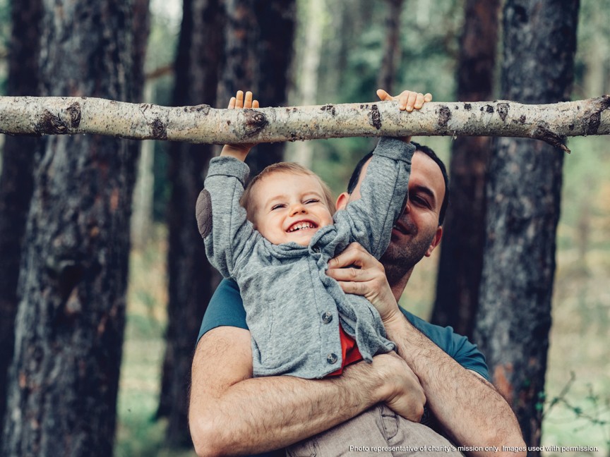 Preschooler climbing log steps to a giant bird's nest at the Ijams Nature Playscape. Impact