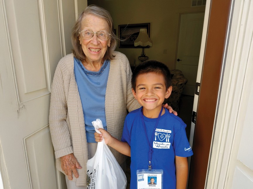 A young volunteer providing nutrition and companionship to an older adult to preserve and enhance the quality of life at home, with dignity and care. Impact