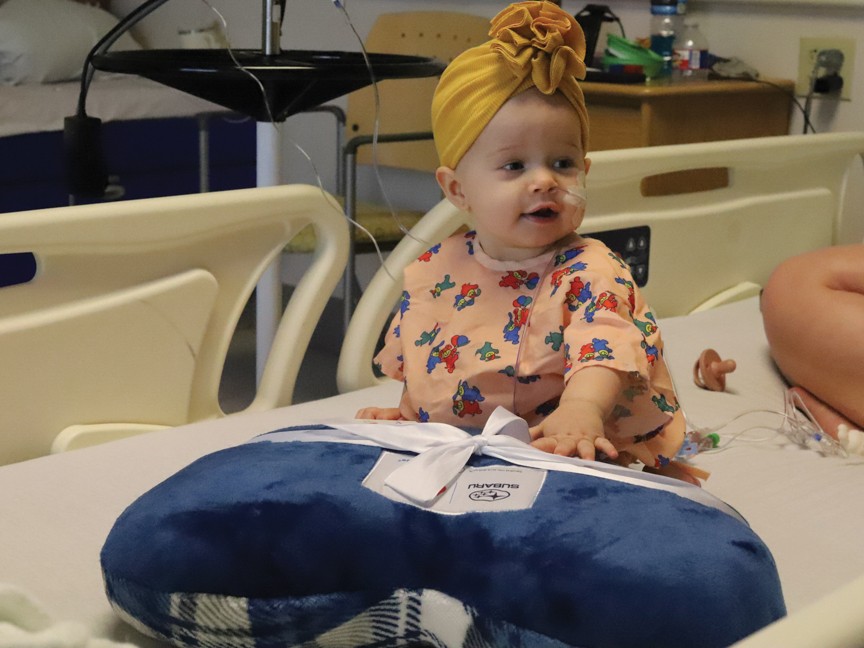 Manning Family Children's patient with a Subaru blanket at our annual distribution with Blood Cancer United (formerly LLS). Impact