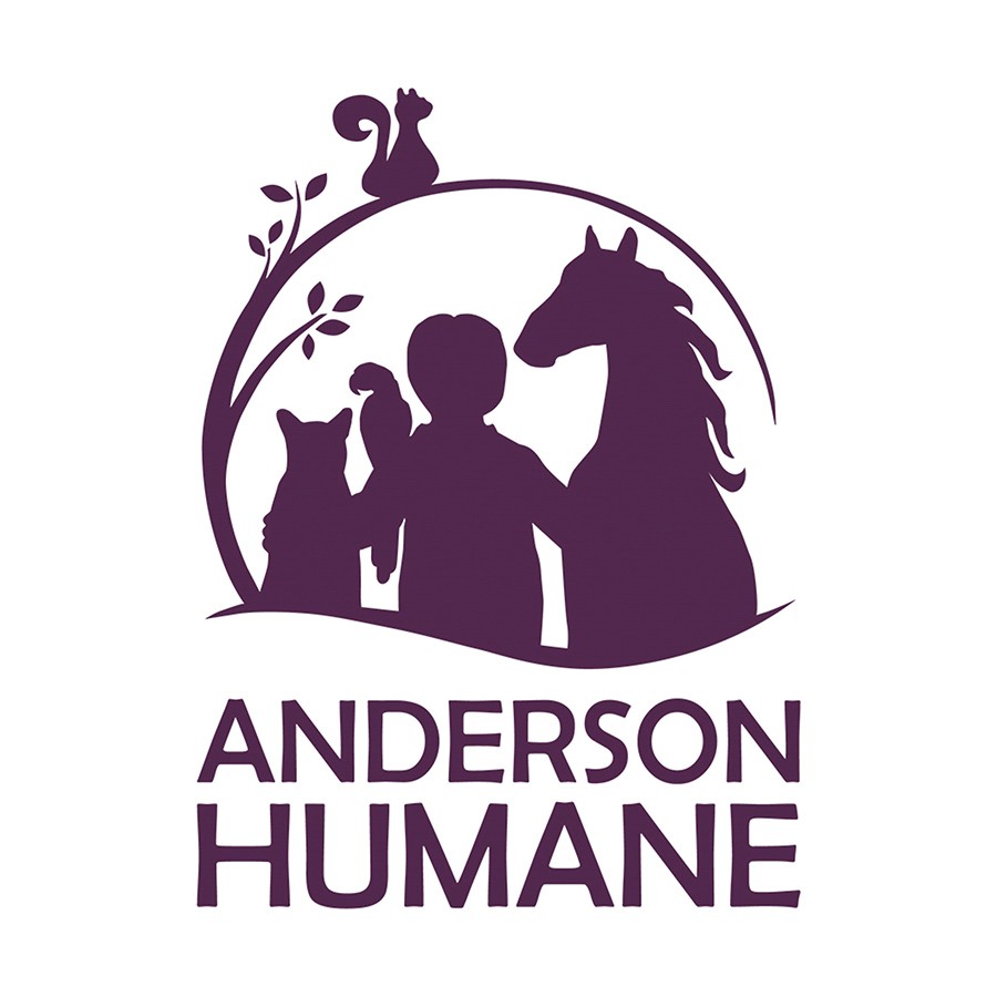 A couple with their dog and newly adopted puppy at an adoption event at Brilliance Subaru.