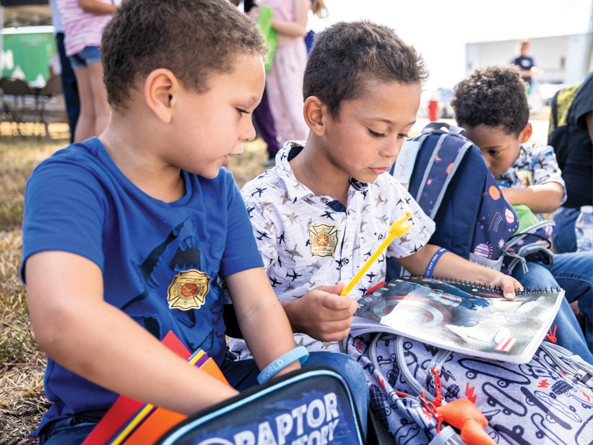 Boys examining their much-needed school supplies. Impact