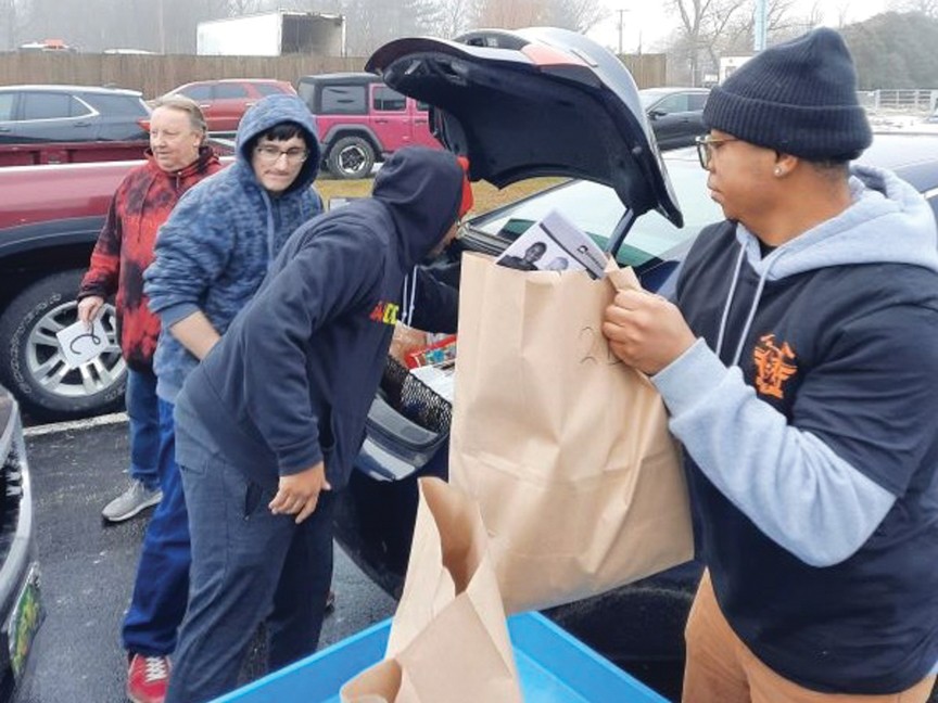 TradeWinds participants helping to distribute bags of food to long lines at TradeWinds Food Pantry. Impact