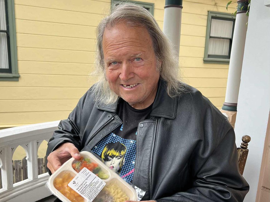 An elderly man with the food he receives from Meals on Wheels. Impact