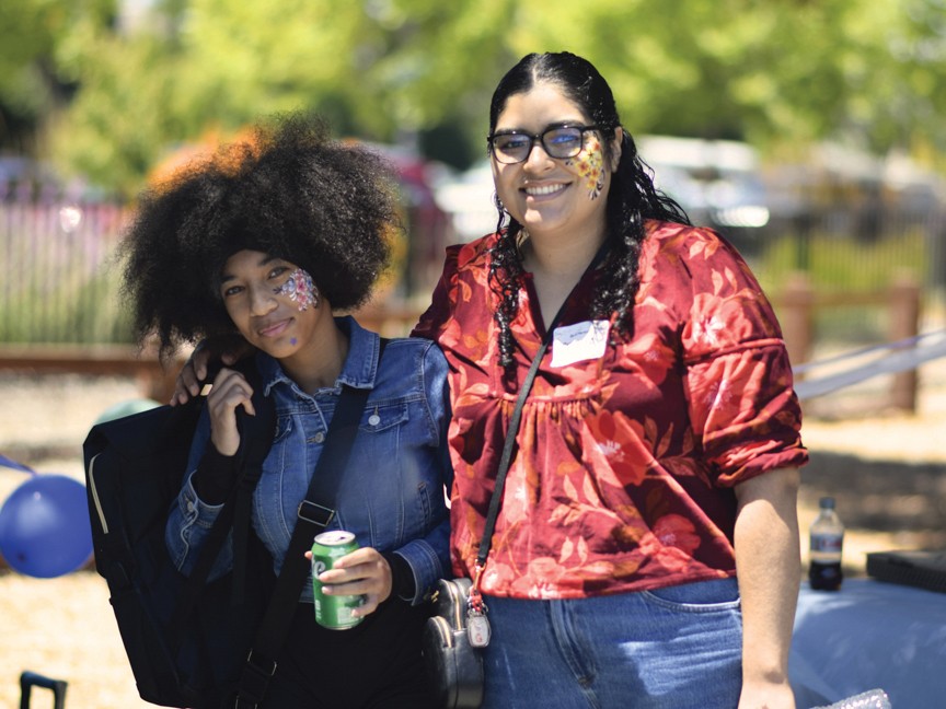 This photo is of one of our youth and their mentor at our summer picnic where she received a backpack before the school year. Impact