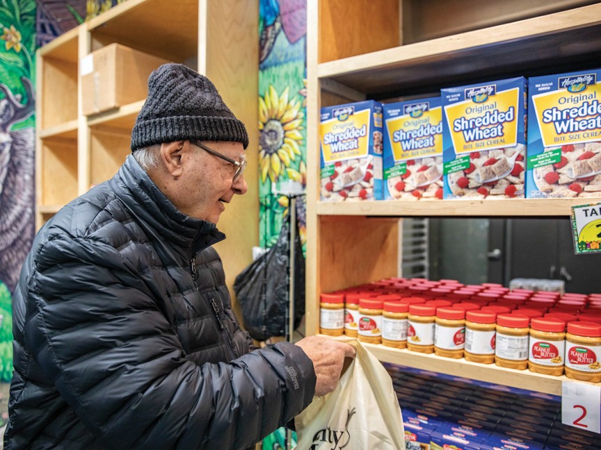 Older man selecting food from our Burlington Food Shelf. Impact
